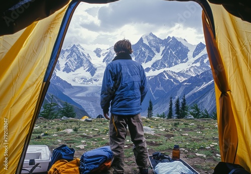 Man Standing in Front of Tent With Mountains in Background