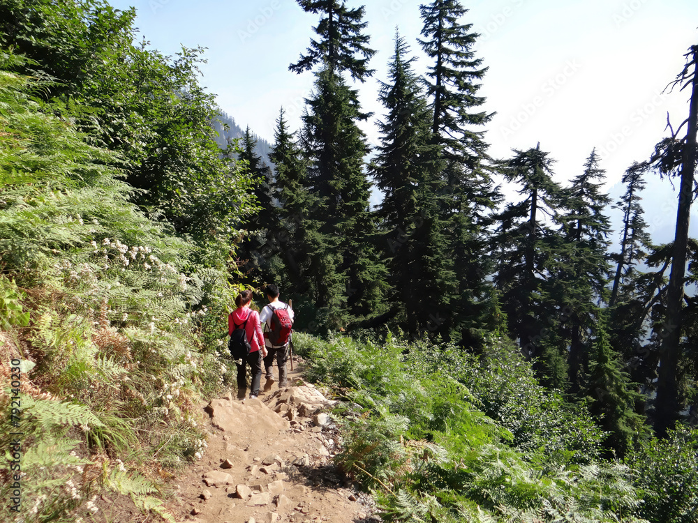 Hikers climbing steep mountain trail Hikers climbing steep mountain trail
