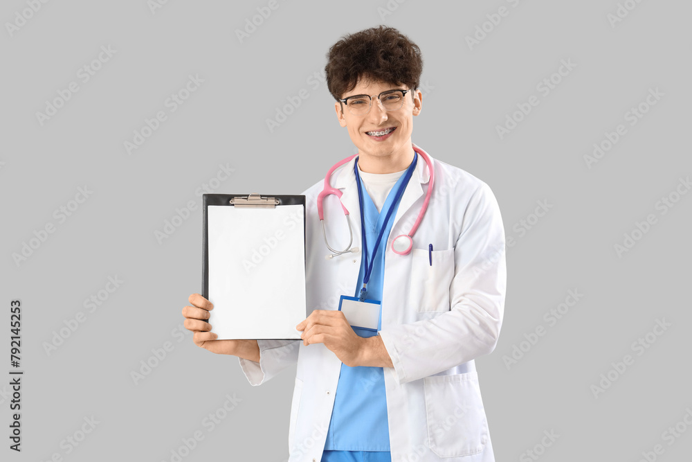 Male medical intern with clipboard on light background Male medical intern with clipboard on light background