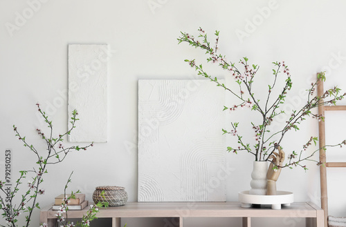 Table and vase with blooming branches in room