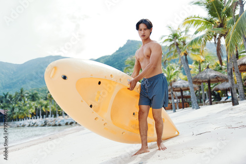 Happy Asian Man Enjoying Kayaking Adventure on Tropical Beach © SHOTPRIME STUDIO