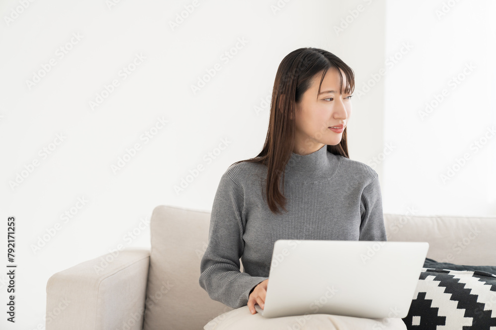部屋でラップトップコンピューターを見る女性 部屋でラップトップコンピューターを見る女性