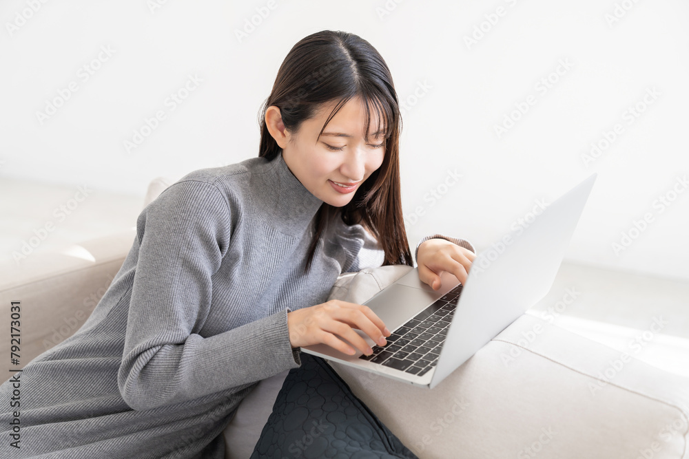 部屋でラップトップコンピューターを見る女性 部屋でラップトップコンピューターを見る女性