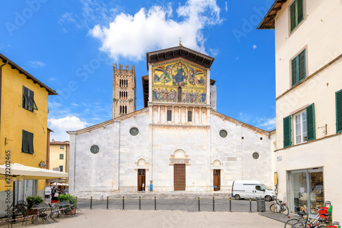 Piazza San Frediano with the facade and bell tower of the San Frediano Basilica, a Romanesque church with golden mosaic facade, inside the walled medieval town of Lucca, Italy. 