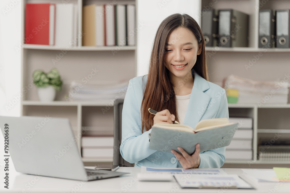 Asian businesswoman uses calculator and laptop to do finance, mathematics, taxes, accounting reports, statistics and business analytical research ideas. Asian businesswoman uses calculator and laptop to do finance, mathematics, taxes, accounting reports, statistics and business analytical research ideas.