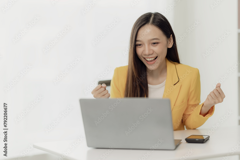 Smiling young woman holds credit card while sitting with laptop at home, shopping online, holding credit card, paying on Internet banking and e-commerce applications Smiling young woman holds credit card while sitting with laptop at home, shopping online, holding credit card, paying on Internet banking and e-commerce applications