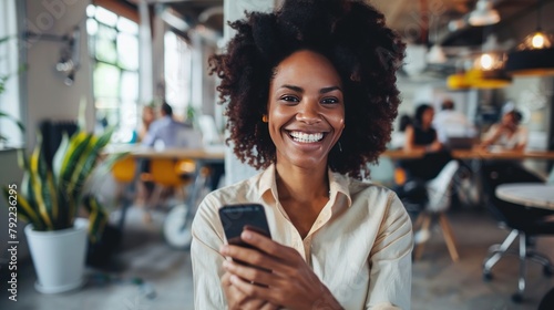 Portrait happy young african businesswoman using smartphone in the office photo