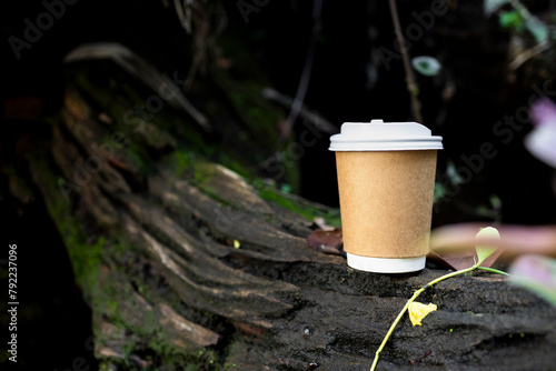 paper cup of coffee in green garden