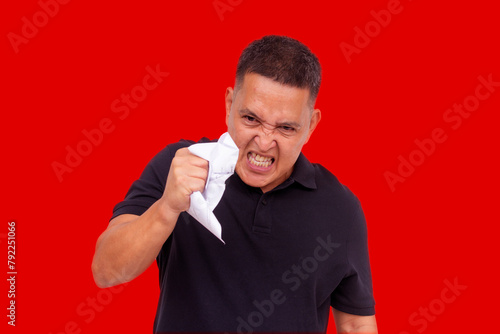 An angry man going amok crumpling his bills, showing irrational compulsive behavior and blind rage. Isolated on a white background.