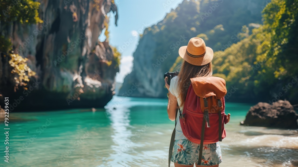 Adventurous woman with backpack photographing limestone cliffs in a tropical destination, concept of exploration and travel