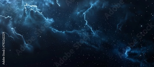 A stunning dark blue galaxy illuminates the sky, filled with twinkling stars and majestic clouds floating in the cosmic expanse photo