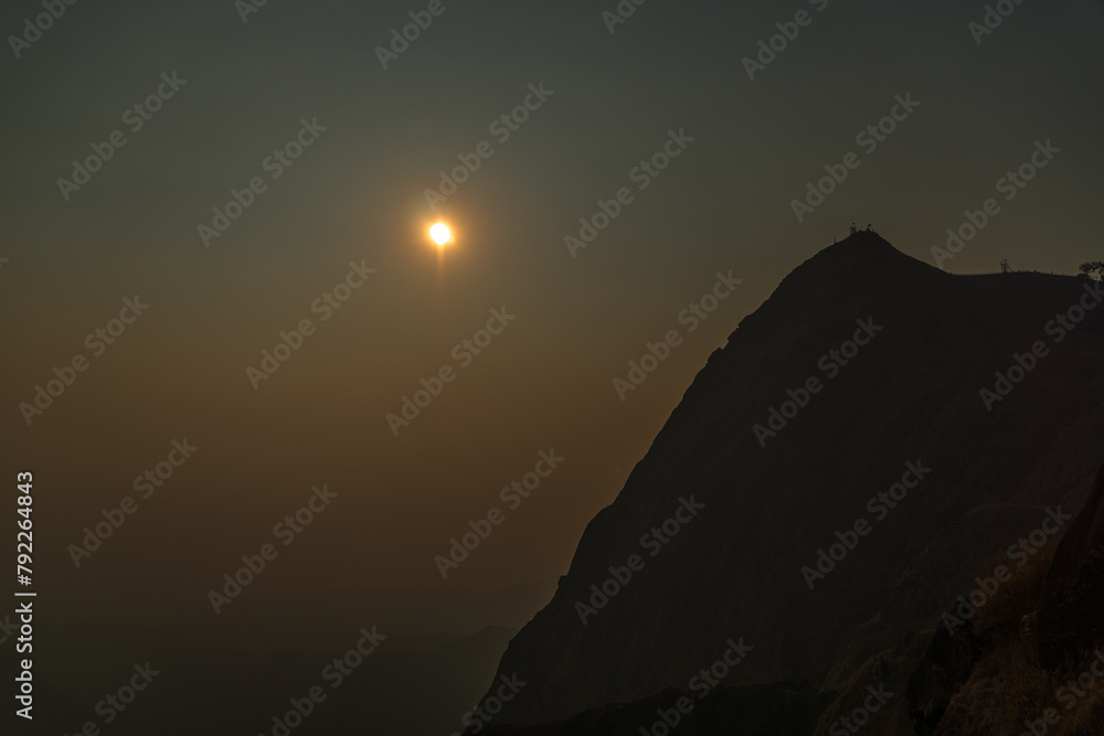 A mountain with a sun in the sky A mountain with a sun in the sky