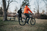 A young adult male cyclist takes a leisurely ride through a tranquil urban park, embodying a healthy, active lifestyle.