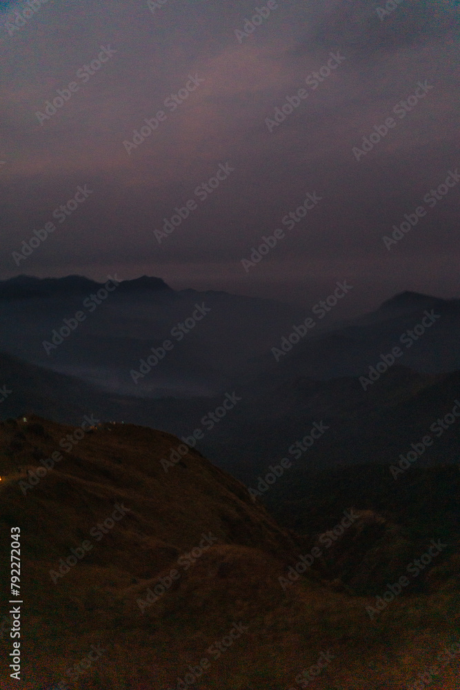 Obraz premium A mountain range with a dark sky in the background