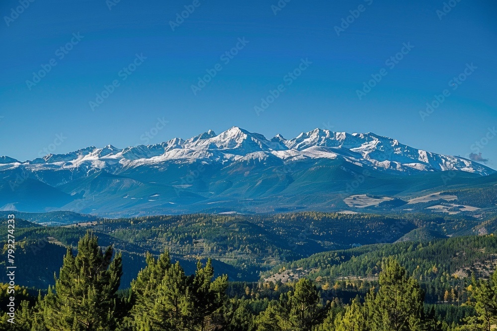 The mountain range has snow-capped peaks and pine forests.