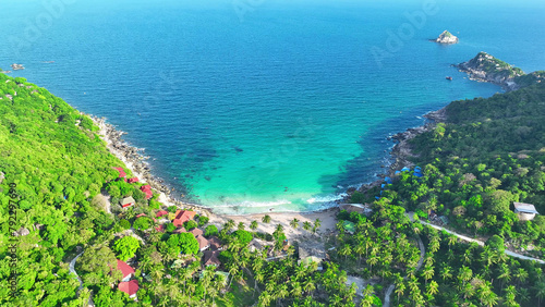 A picturesque resort nestled on verdant sandy shores, where the gentle caress of emerald waves invites you to unwind in blissful harmony with nature's splendor. Koh Tao, Southern Thailand.  © Punyawee