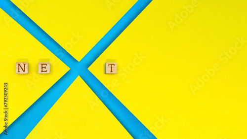 黄色い背景でNEXTのアルファベットのXをデザインした青色の装飾 photo