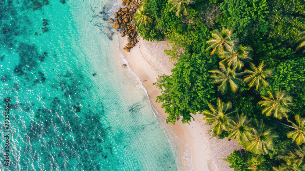 Obraz premium Aerial view of clear turquoise water near a sandy beach with coconut trees on an island on a sunny day