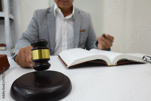 Lawyer siting at in Law office Justice law and wooden gavel tool on desk .concept