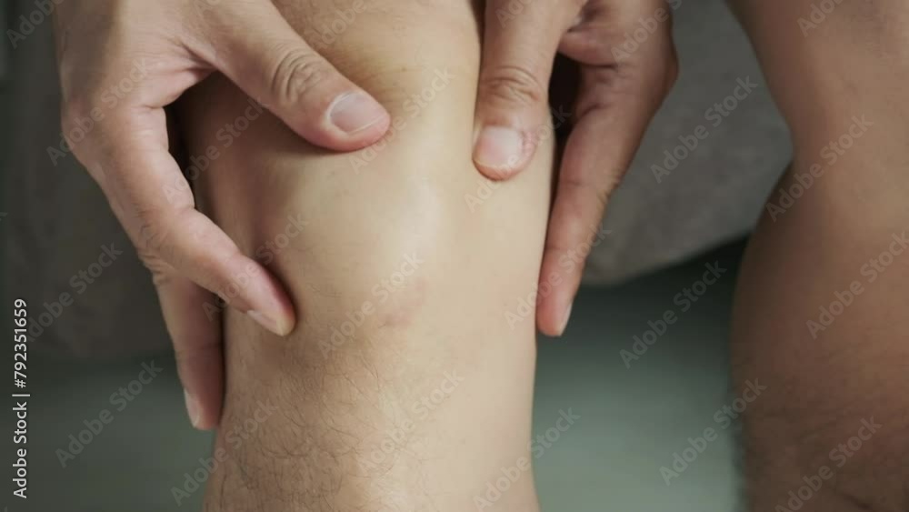 Man with knee pain, he puts his hand on his knee, pain point from osteoarthritis and osteoarthritis, medical concept and treatment Man with knee pain, he puts his hand on his knee, pain point from osteoarthritis and osteoarthritis, medical concept and treatment