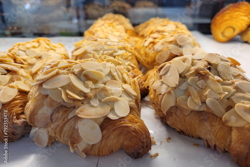 Fresh baked butter croissants with almond on tray in pastry shop