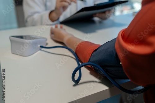 A doctor is examining a patient in a private examination room to check blood pressure and heart rate to make a preliminary diagnosis, A patient is being examined by a doctor at a hospital.