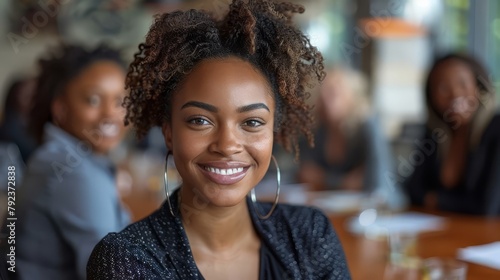 Happy businesswoman sitting in company conference room with coworkers