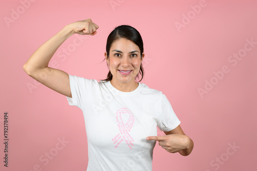 strong woman on isolated pink background. concept of fighting breast cancer. woman with pink ribbon