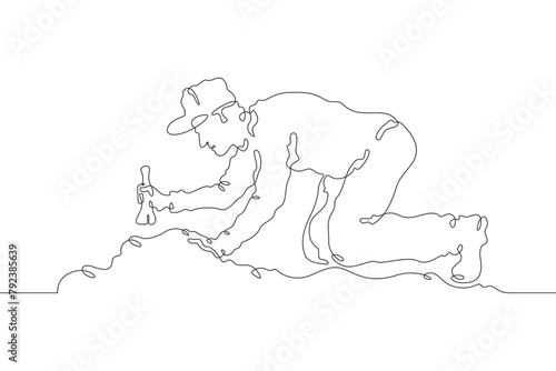 Archaeologist at an excavation. An archaeologist with tools in hand conducts historical research. Historian. Archeology. One continuous line . Line art. Minimal single line.White background. One line 