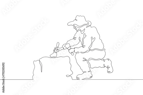 Archaeologist at an excavation. An archaeologist with tools in hand conducts historical research. Historian. Archeology. One continuous line . Line art. Minimal single line.White background. One line 