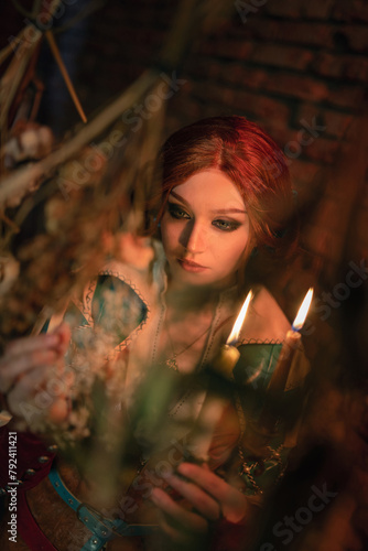 Beautiful young enchantress on dark background. WItchcraft. photo