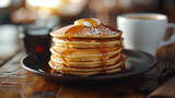 Delicious American pancakes on dark plate next to a cup of fresh coffee. With maple sirup. On bistro countertop. 