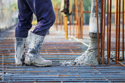 Concrete is poured into a steel reinforcement frame at a construction site. photo