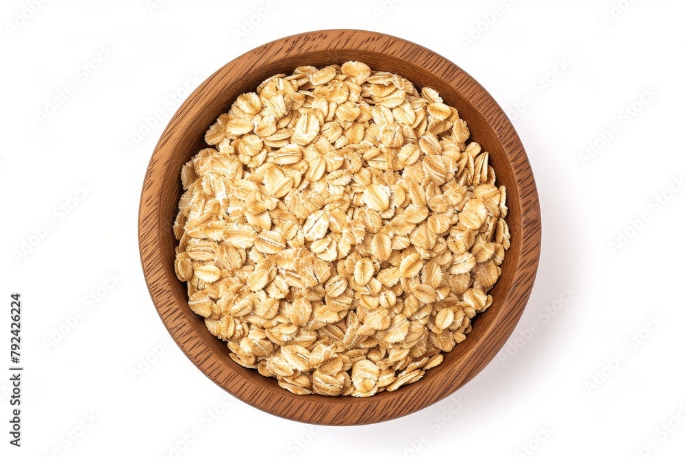 Top view of oat flakes in wooden bowl isolated on white background