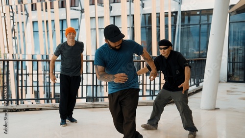 Hip hop team dance break dance while multicultural friend surrounded and clapping hands to cheer or encourage his friend to dance. Active and energetic street dance. Outdoor sport 2024. Endeavor.