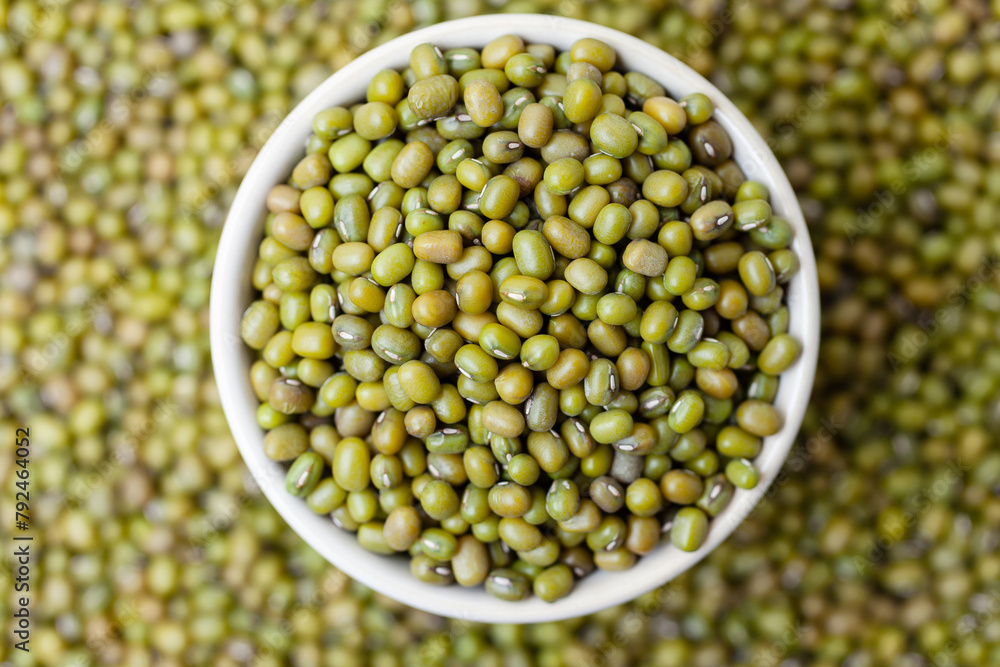 Uncooked, green mung beans in bowl. Dry mung beans grains. Top view - obrazy, fototapety, plakaty 