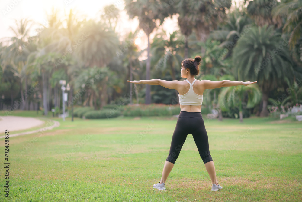 Sportswoman. Fit young Asian woman with sportswear stretching muscle in park before running and enjoying healthy outdoor. Fitness runner girl in public park. Wellness being concept