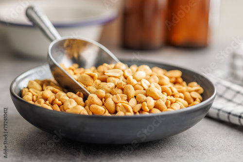 Salted roasted peanuts on plate  on kitchen table