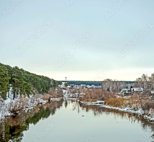 banks of the winter river covered with forest