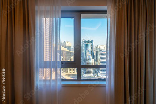 view through bedroom window to cityscape with modern new buildings, Dubai, United Arab Emirates 