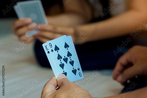 Close-up view of the cards in the player's hand. Get King and 9 Spades cards. Concept Play cards at leisure or as a hobby. Soft and selective focus.