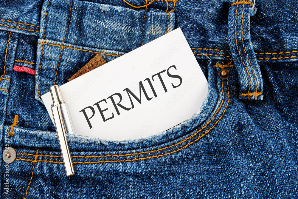 A word PERMITS on a business card peeking out of a jeans pocket - obrazy, fototapety, plakaty 