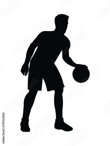 Black silhouette of a basketball player who hits the ball dribbling and standing in a half turn photo