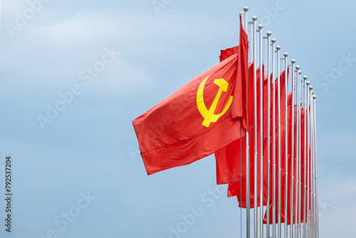 Billede på lærred Large communist flags floating in the wind with a blue sky background