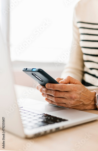 Close-up view of woman hands using cell phone device at office workplace. Business and entrepreneur people concept.