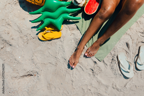 Sunbathe at the beach Women's feet, sandals and fruit © artrachen