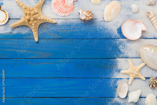 Sea shells, starfish and sand on wooden background, top view
