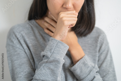Close-up of Female asian have a flu and coughing isolated on background © Pormezz