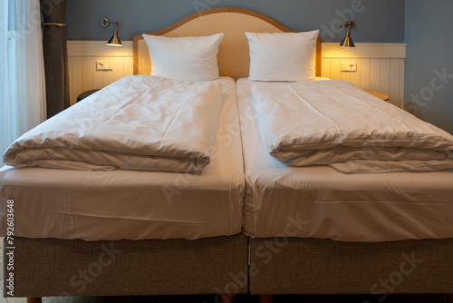 Large double bed bedside tables and lamps in the hotel room. Hotel furniture. photo