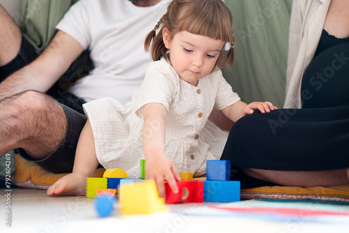 Toddler girl playing with colorful blocks at home photo
